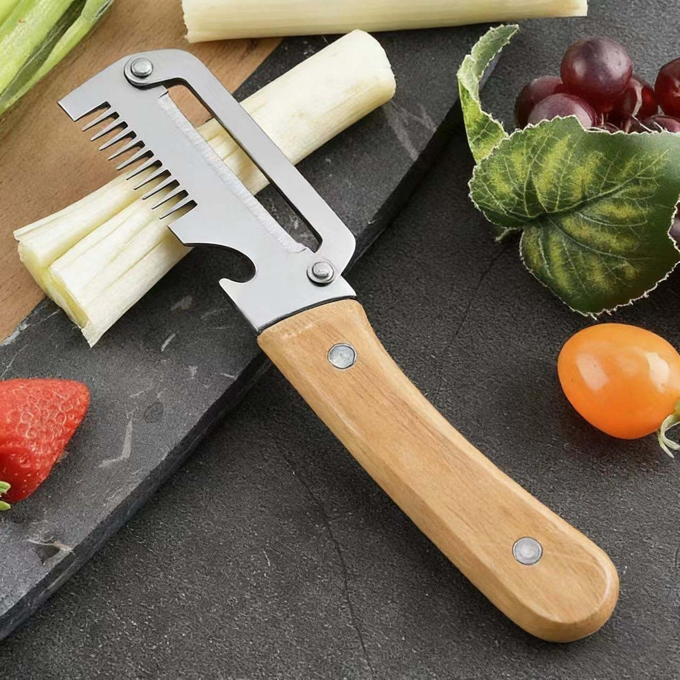 Vegetable peeler with wooden handle on a dark surface with fruits and vegetables.