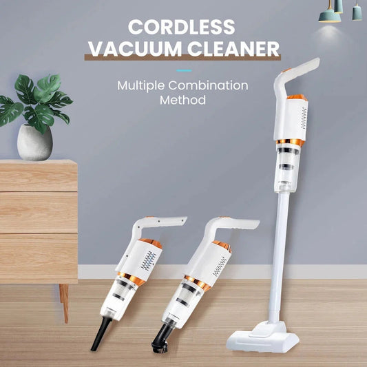 A white cordless vacuum cleaner with orange and black accents, shown in a vertical position with a hose and a floor brush, against a background of a wooden furniture set against a wall with a plant and a lamp.